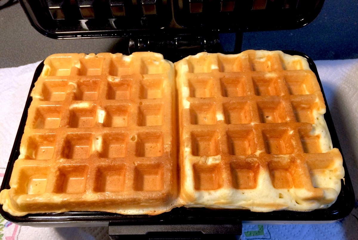 Waffles cooking on a waffle maker © French Moments