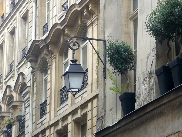 Lamp post attached to the façade of a street in central Paris © French Moments