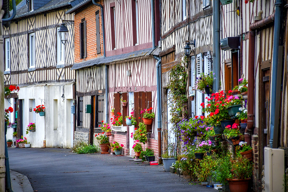 An old narrow street lined with half-timbered houses in Moyaux, Pays d'Auge